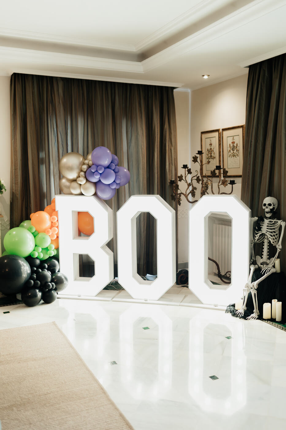 Light-up BOO letters beside a skeleton and candles, Halloween villa decoration Marbella