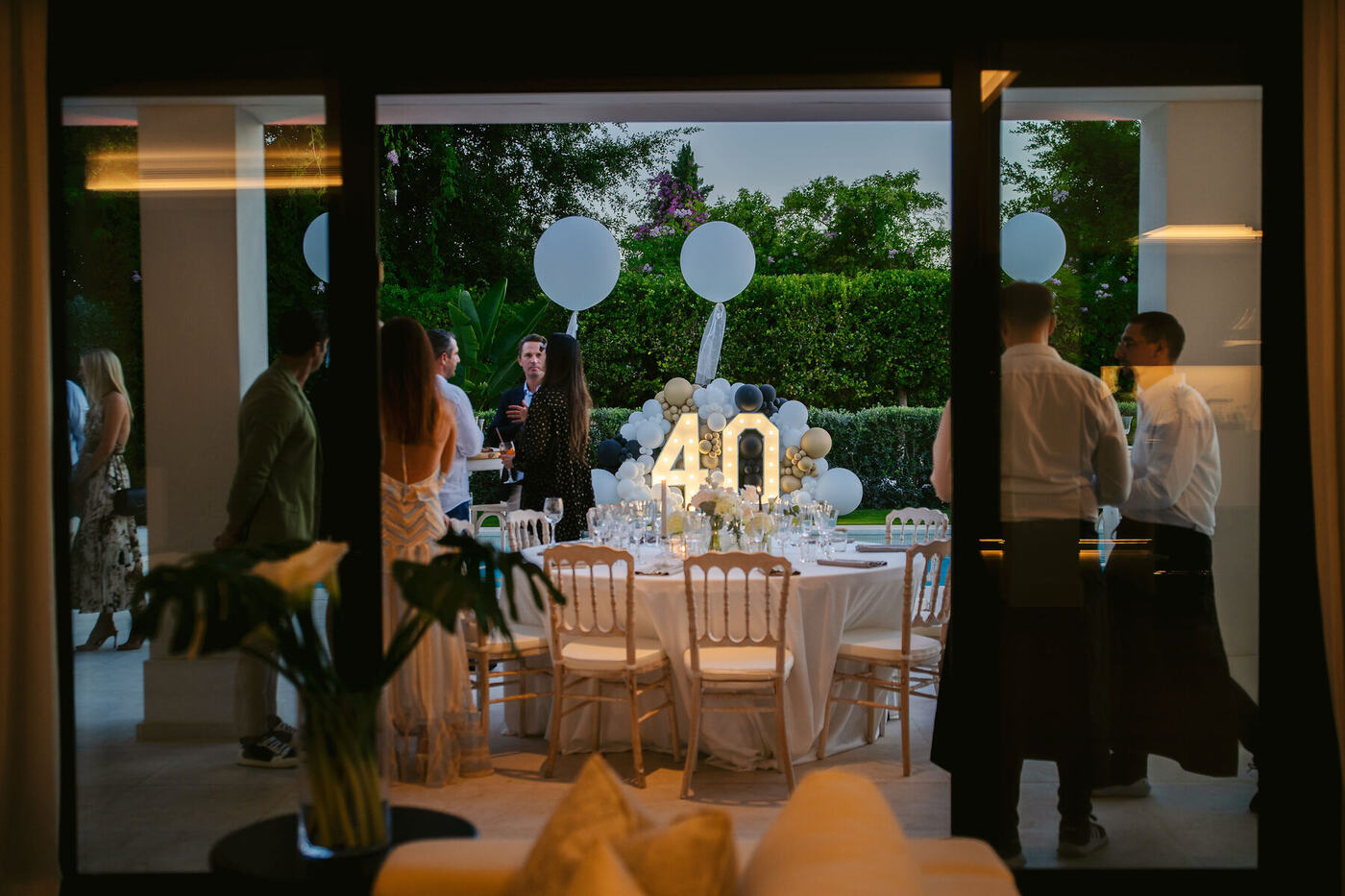 Evening dinner setting glowing beside the pool, Marbella villa 40th birthday