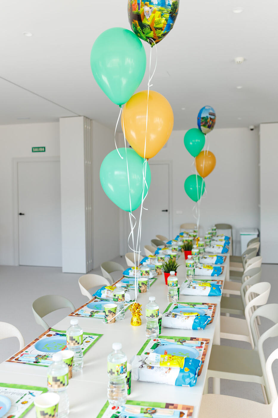 Long kids party table with green and gold balloon bunches, BolaBoom Marbella